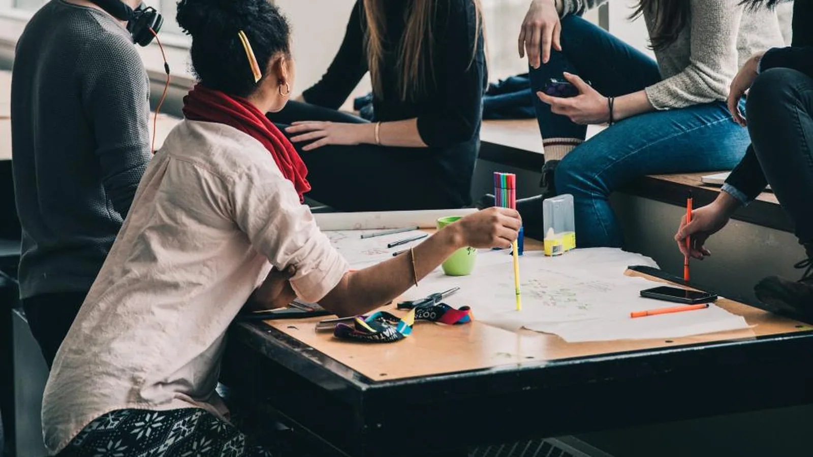 Grupo de estudantes estudando juntos numa mesa com cadernos