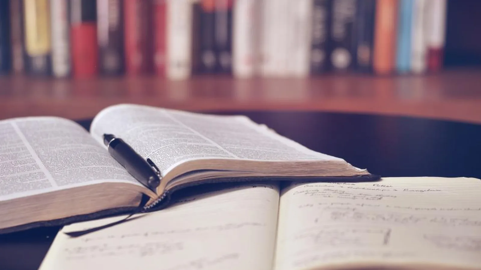 Livro aberto com anotações sobre uma mesa